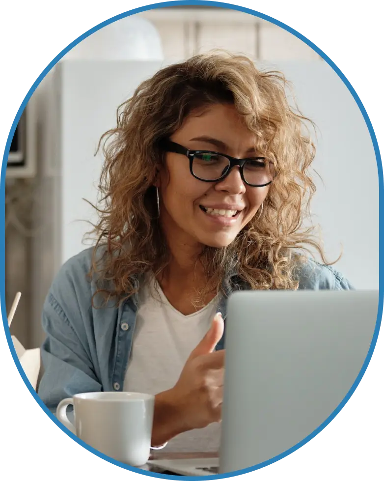 women in blue smiling towards laptop